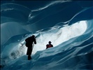 Jem exploring an amazing blue ice arch, Fox Glacier